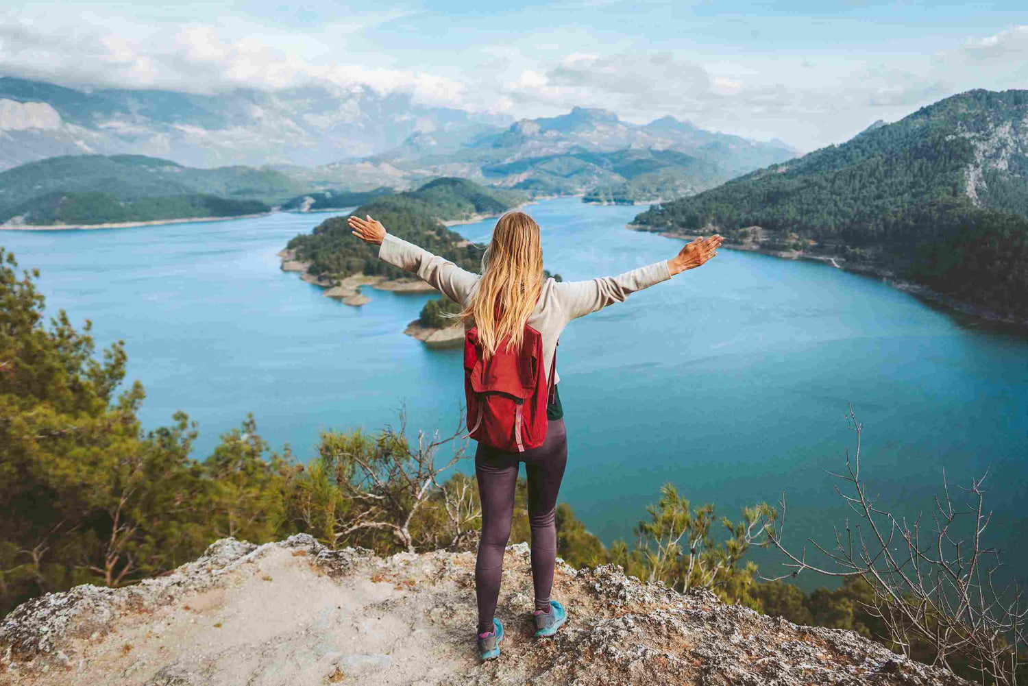 Touristin hebt die Hände und genießt den Seeblick